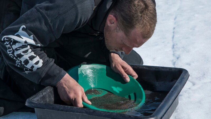 Kris Kellys pans out more material in a water basin. – Bild: Discovery Channel /​ Discovery Communications