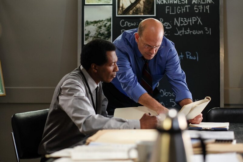 Flugunfallermittler John Delisi (gespielt von Darrin Baker) berät sich mit einem anderen Ermittler (gespielt von einem Hintergrunddarsteller). (Bildnachweis: Cineflix/​Darren Goldstein) – Bild: PLURIMEDIA (Cineflix /​ Darren Goldstein)