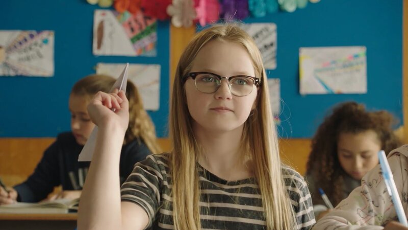 In einer Rückblende wirft Floor (Bobbie Mulder) einen Papierflieger durch die Klasse. Sie möchte Wouter fragen, ob er ihr Freund sein möchte. Doch der Flieger landet auf Freeks Tisch. – Bild: „Bild: ND …