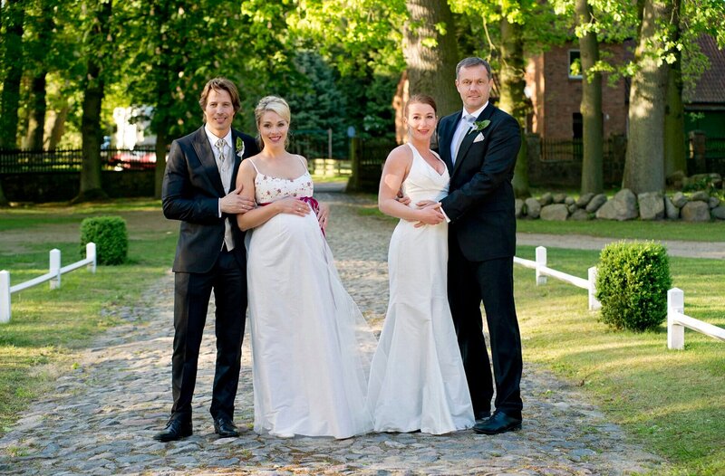 Doppel-Hochzeit zu fünft bei Rote Rosen: Die Freundinnen Britta und Carla strahlen mit ihren zukünftigen Ehemännern Ben und Torben um die Wette. Stolz präsentiert die hochschwangere Britta ihren Baby-Bauch und hofft, dass der Nachwuchs nicht ausgerechnet an ihrem Hochzeitstag das Licht der Welt erblicken will. – Bild: ARD/​Thorsten Jander