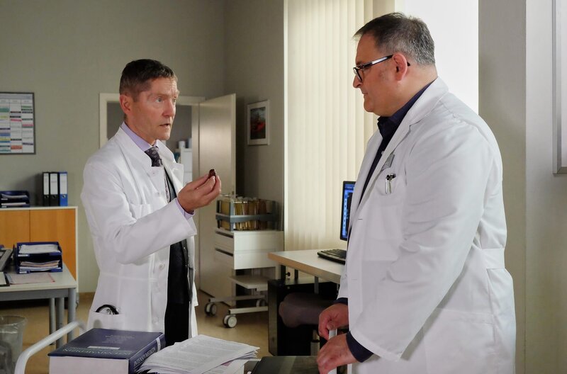 Dr. Rolf Kaminski (Udo Schenk, li.) versucht Hans-Peter Brenner (Michael Trischan, re.) vor sich selbst zu schützen. Hans-Peters Mutter kann in den Augen der gesamten Ärzteschaft den Krebs einfach nicht mehr besiegen, dafür ist er zu weit fortgeschritten. Doch Hans-Peter wälzt sämtliche Studien, alle Bücher, jeden noch so kleinen Strohhalm ergreift er. – Bild: MDR/​Sebastian Kiss