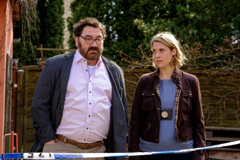 Elmar Fiedler (Heiko Pinkowski, l.) ist geschockt. Seine Frau wurde in der gemeinsamen Gesundheitspraxis tot aufgefunden. Tamara Meurer (Anja Pahl, r.) befragt ihn behutsam. – Bild: ZDF