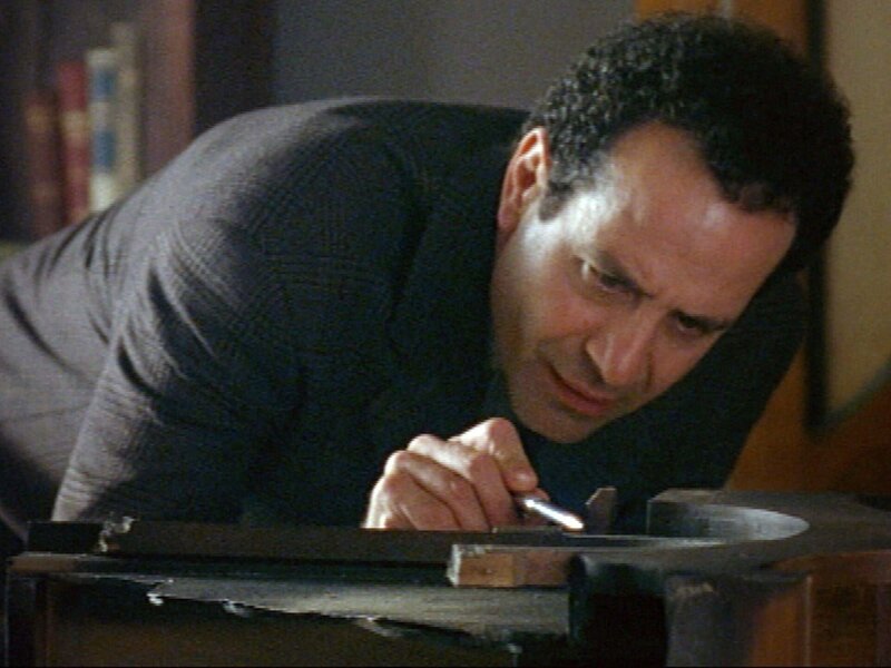 Auf die reiche Amanda Babbage wurde ein Briefbombenanschlag verübt. Monk (Tony Shalhoub) untersucht die Reste des explodierten Pakets. – Bild: SUPER RTL