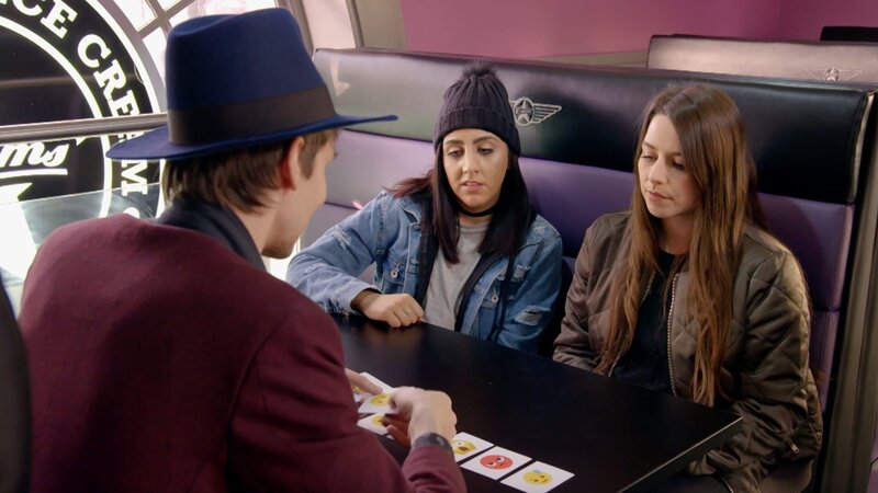 ein Zauberer zeigt zwei Frauen einen Kartentrick – Bild: CuriosityStream-Inc.