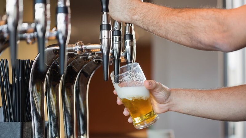 Barmans arms pulling a pint of beer behind the bar – Bild: Wavebreakmedia /​ Getty Images/​iStockphoto /​ iStockphoto;GettyImages-50308431 /​ Wavebreakmedia