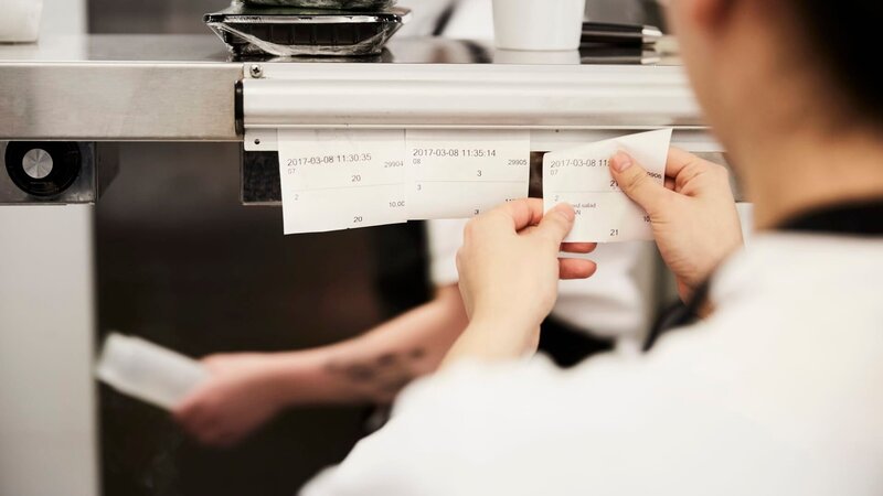 Cropped image of female chef reading order tickets in commercial kitchen – Bild: Maskot /​ Getty Images/​Maskot /​ Maskot /​ Copyright Maskot .