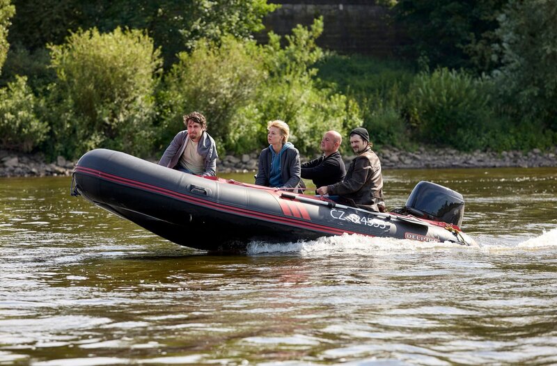Vaclav (Robin Meisner, r) hat Tonja Hoffmann (Magdalena Kosch, M.) entführt. Sie fahren mit dem Schlauchboot flussabwärts (mit Komparsen). – Bild: ARD/​Rudolf Wernicke
