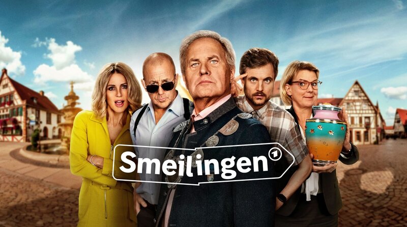 Willkommen in Smeilingen, dem garantiert komischsten Dorf Deutschlands! Uwe Ochsenknecht als Bürgermeister Markus Seider (vorne mi.), Michelle Hunziker (li.) spielt sich selbst, Heino Ferch (2.v.li.) spielt den Polizisten Hauke Mayer, Phil Laude spielt „Alman“ Frank Stimpel (2.v.re.), Mirja Boes spielt die Bestatterin Frieda Grabowski (re.) – Bild: ARD/​SWR/​Constantin Entertainment