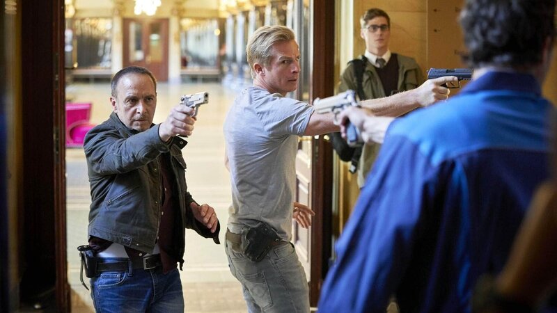 Während einer Personenüberprüfung in einem Hotel durch Semir (Erdogan Atalay, l.) und Paul (Daniel Roesner) wird der Journalist Petzold (Timothy Boldt, hinten) Zeuge, wie seine Interviewpartnerin Krüger, die neue Polizeipräsidentin von Köln, als Geisel genommen wird. – Bild: RTL /​ Guido Engels