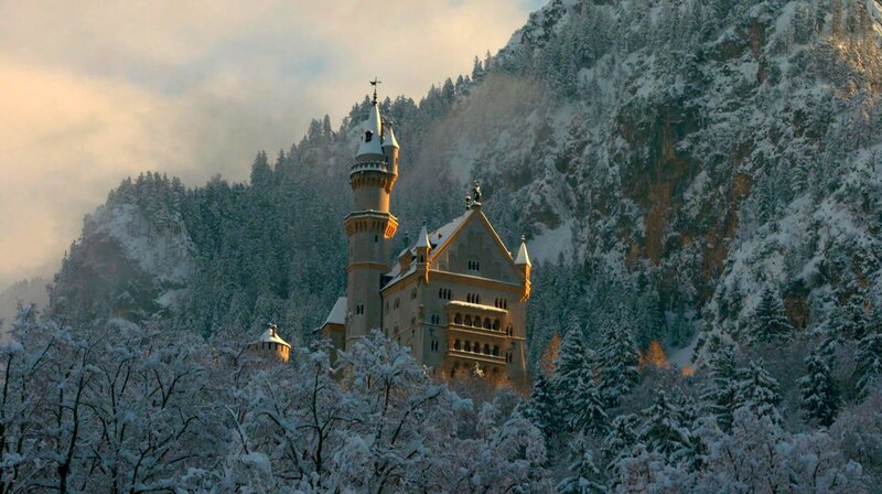 Erste Sonnenstrahlen fallen auf das winterliche Schloss Neuschwanstein. – Bild: BR