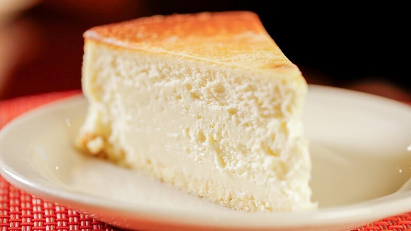 Der berühmte New-York-Käsekuchen von „Junior’s“ ist ein reichhaltiger, samtiger Vanillepuddingkuchen aus gesüßtem Frischkäse, der auf einer weißen Biskuitkruste gebacken wird. – Bild: ORF 1