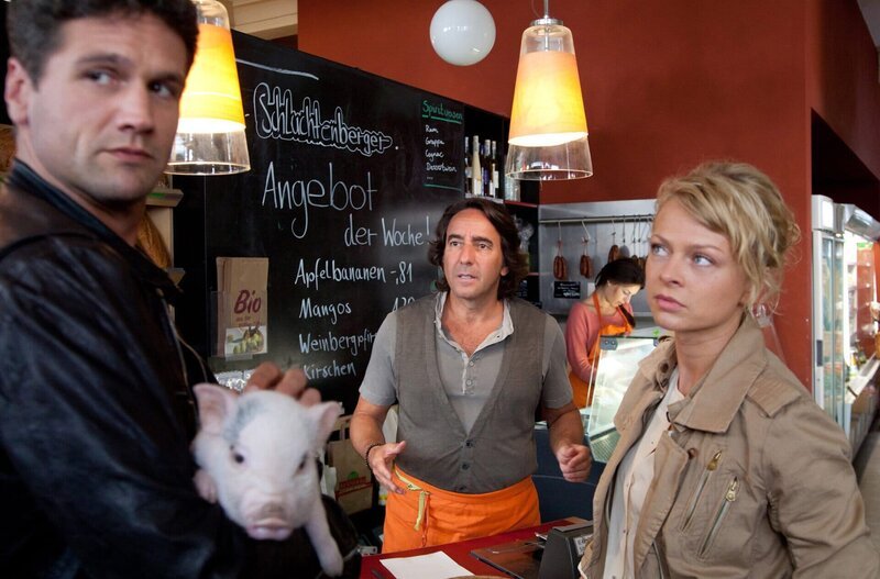 Kristina Katzer (Isabell Gerschke, r.) und Lukas Hundt (Oliver Franck, l.), der das Minischwein in seine Obhut genommen hat, versuchen herauszufinden, ob Bioladenbesitzer Maik Schluchtenberger (Dieter Landuris, M.) hinter dem Mord an Metzgermeister Lehmann steckt. – Bild: MDR/​ARD/​Andreas Wünschirs
