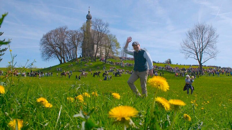Markus Tremmel (im Bild) ist wieder auf seinem E-Bike unterwegs zu den schönsten Veranstaltungen im ganzen Freistaat. Georgiritt in Traunstein an der Ettendorfer Wallfahrtskirche. – Bild: BR/​isarflimmern fernsehproduktion GmbH & Cutflow GmbH