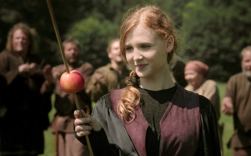 Prinzessin Elisabeth (Isolda Dychauk) schießt einen Pfeil in hohem Bogen in einen Apfel – Bild: Radio Bremen/​Jo Molitoris