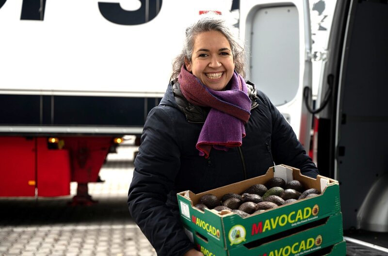 Günes Seyfarth mit einer Kiste voller Avocados. – Bild: BR/​Tabea Hofmann
