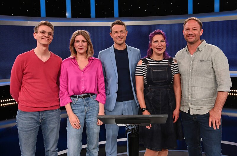 Moderator Alexander Bommes (M.) mit den Kandidat:innen: Bremen-Vier-Hörer Jonas Heise (l.), Bremen-Vier-Moderatorin Tine Kuntze (2.v.l.), hr3-Hörerein Schahla Lila (2.v.r.) und hr3-Moderator Tobias Kämmerer (r.). – Bild: ARD/​Uwe Ernst