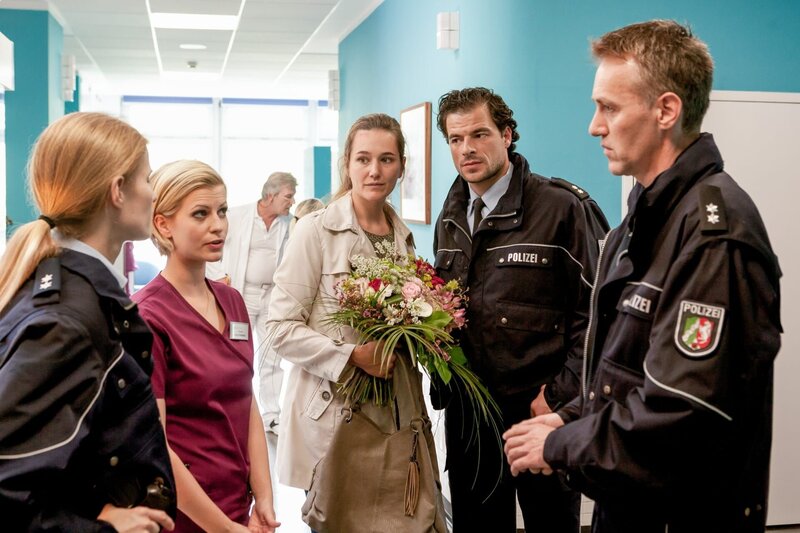 Eine anonyme Anruferin hat bei der Polizei eine Anzeige wegen häuslicher Gewalt gemeldet. POM Apitz (Daniel Drewes, r.) und seine Kollegin (Komparse) sind überrascht, als sie beim Eintreffen im Krankenhaus auf ihren Kollegen Müller (Tobias Licht, 2.v.r.) treffen. – Bild: ORF/​ZDF/​Kai Schulz