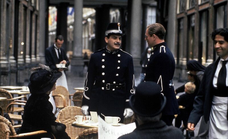 „Agatha Christie’s Poirot“, „Die Pralinenschachtel.“ Poirot kehrt nach über 20 Jahren wieder in seine Heimatstadt Brüssel zurück, um Chief Inspector Japp bei einer Würdigung seiner Arbeit durch die belgische Polizei zur Seite zu stehen. Dabei trifft er auf alte Bekannte, und die Sprache kommt auf einen Fall, den Poirot nicht lösen konnte. Er sollte damals auf Bitten einer reizenden Dame aufklären, ob der belgische Minister Paul Deroulard eines natürlichen Todes gestorben ist oder ermordet wurde. Jetzt, Jahre nach dem Ereignis, ist für Poirot der Zeitpunkt gekommen, die Wahrheit aufzudecken und seine Reputation zu retten. Mit der Episode „Die Pralinenschachtel“ unternimmt die Serie einen Sprung in Hercule Poirots Vergangenheit, und zwar in die Jahre vor dem 1. Weltkrieg. Poirot ist hier das erste Mal als Privatdetektiv tätig. Für die Ermittlungen hat er sich Urlaub von seinem Polizeidienst genommen und versucht nun auf eigene Faust, den Tod des belgischen Ministers Paul Deroulard zu klären, der offiziell zu den Akten gelegt wurde, da man von einer natürlichen Todesursache ausgeht. Poirots beruflicher Ehrgeiz wird durch die zauberhafte Virginie Mesnard geweckt, die glaubt, dass Deroulard ermordet wurde. Sie wiederum ist so begeistert von Poirots Einsatz, dass sie ihm die Brosche in Vasenform schenkt, die er fortan immer trägt.Im Bild (v.li.): Anna Chancellor (Virginie Mesnard), David Suchet (Hercule Poirot), Jonathan Hackett (Claude Chantalier). – Bild: One