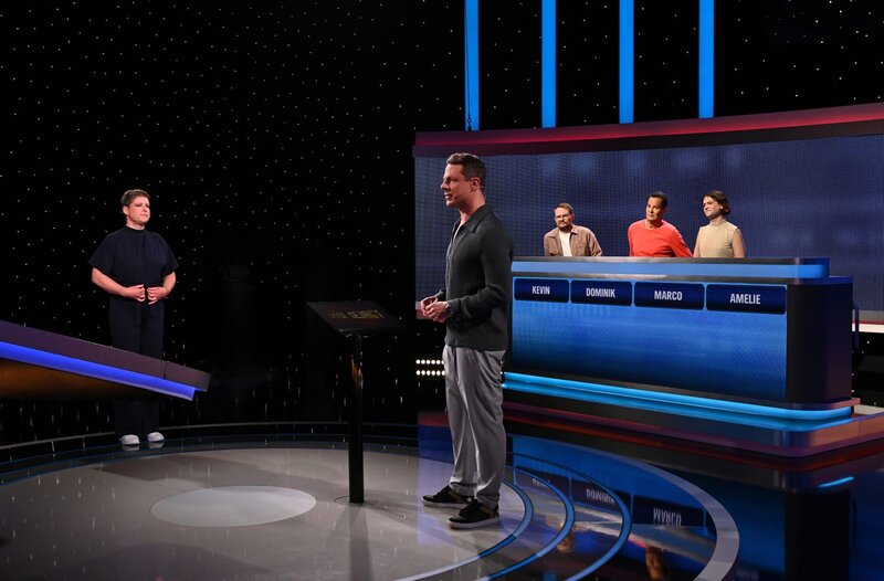 Moderator Alexander Bommes (M.) mit den Kandidaten: Radio-Eins-Moderatorin Amelie Ernst (l.), Kevin Holtmann (3.v.r.), BR3-Moderator Dominik Pöll (2.v.r.) und Marco Bock (r.). – Bild: ARD/​Uwe Ernst