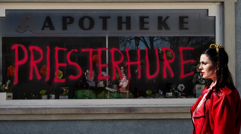 Tina (Anita Eichhorn) steht geschockt vor dem verschmierten Schaufenster der Apotheke. – Bild: BR/​Lena Semmelroggen