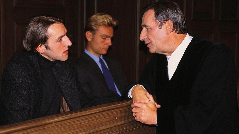 Oberstaatsanwalt Lotze (Henry van Lyck, r.) verhört im Gerichtssaal den angeklagten Frank Bethke (Andreas Schmidt, li.; Mi. Komparse). – Bild: MG RTL D