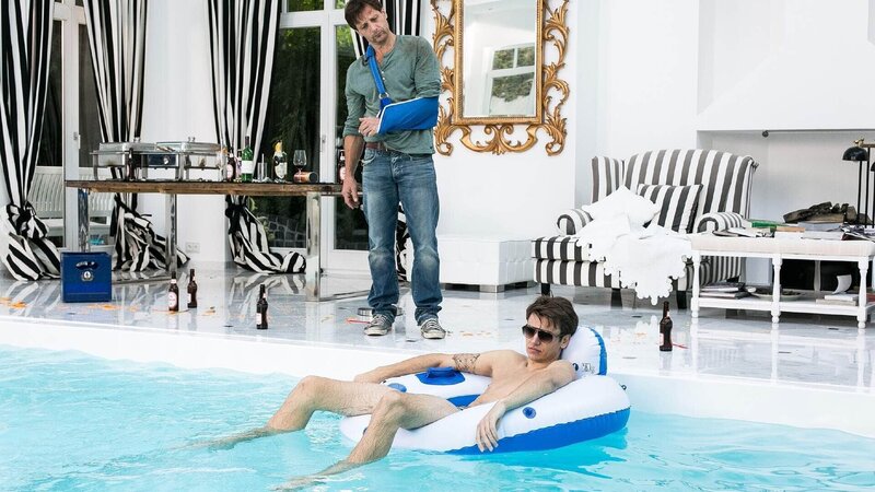 Als Stefan (Hendrik Duryn, l.) den verkaterten Rene (Michael Glantschnig) ihm Pool vorfindet, macht er ihm bezüglich der Abiprüfung und Mila Beine … – Bild: TVNOW /​ Kai Schulz /​ Sony Pictures FFP