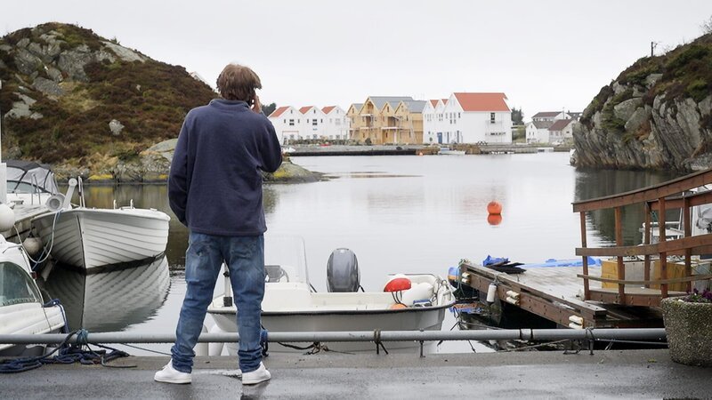 Jake telefoniert und schaut aufs Wasser hinaus. – Bild: Warner Bros. Discovery