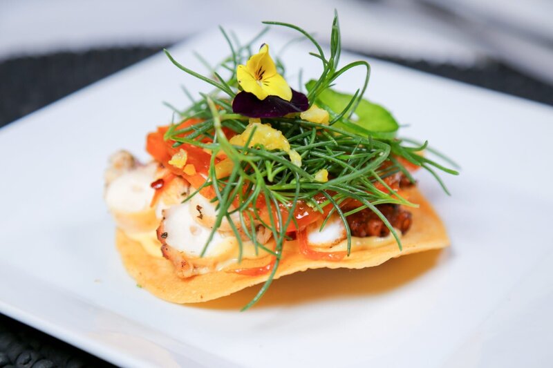 Die „Tostada de Pulpo“ ist eine knusprig frittierte Tostada nach mexikanischer Art mit sautiertem Oktopus aus nahegelegenen mexikanischen Gewässern, einer karamellisierten Zwiebelpaste, gehackter eingelegter Zitrone, frischem Seegras und Jalapeno. – Bild: ORF/​Warner/​The Travel Channel