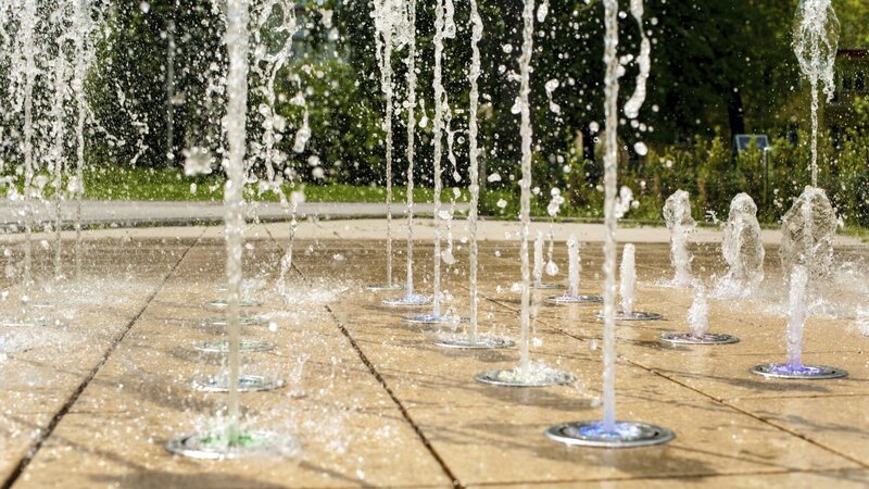 Many small splashing dancing fountains in summer Warsaw park – Bild: Discovery