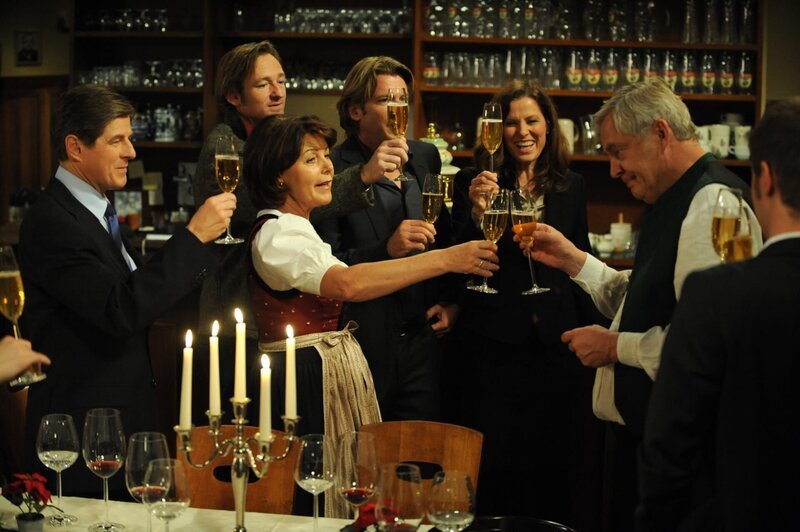 Die Lansinger stoßen gemeinsam auf eine schöne Weihnacht an. Von links: Roland Bamberger (Horst Kummeth), Gregor (Holger M. Wilhelm), Rosi Brunner (Brigitte Walbrun), Sebastian Wildner (Herbert Ulrich), Annalena (Heidrun Gärtner) und Joseph Brunner (Wilhelm Manske). – Bild: BR/​Marco Orlando Pichler