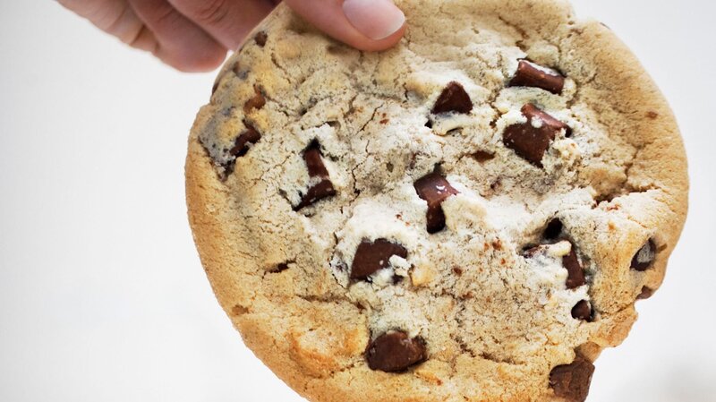 Hand dipping large chocolate chip cookie in small coffee cup – Bild: Robert Daly /​ Getty Images/​OJO Images