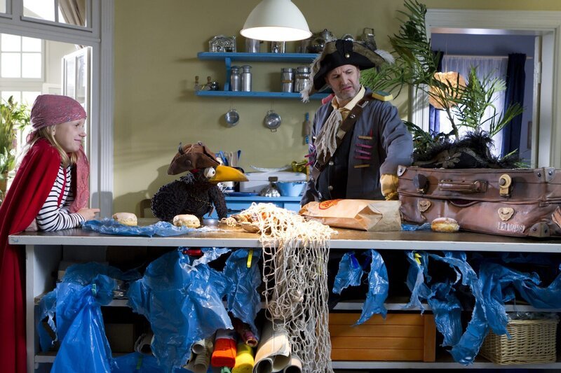 Die Mathepiraten Melanie (Marie Becker), Rabe Rudi (Werner Knoedgen), Herbert (Christian Klischat) und der Koffer (Thomas Rohloff) lassen sich ihren gewonnenen „Goldschatz“ schmecken. – Bild: ZDF/​Zia Ziarno