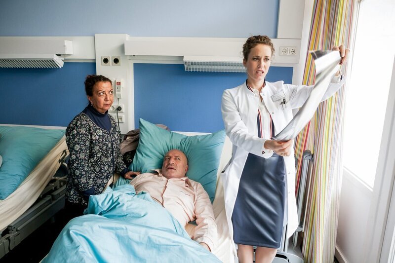 Dr. von Arnstett (Claudia Hiersche, r.) zeigt Sheliffa (Lilay Huser, l.) und Mehmet Ertek (Orhan Güner) Röntgenbilder, auf denen zu sehen ist, dass Herr Ertek Kieselsteine im Magen hat. – Bild: ORF/​ZDF/​Kai Schulz