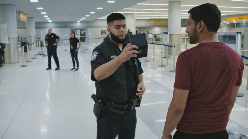 Polizist Leon kontrolliert den Pass eines Passagiers. (National Geographic) – Bild: 2021 NGC Network US, LLC. All rights reserved. Lizenzbild frei