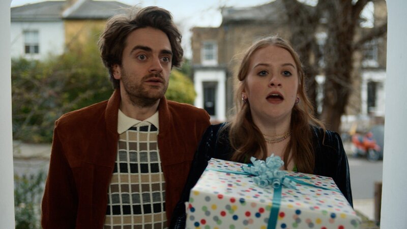 Jizzlord (Luke Rollason, l.) und Jen (Máiréad Tyers, r.) sind bei Nora eingeladen. Jizzlords Sohn Alfie hat Geburtstag und sie haben ein großes Geschenk für ihn mitgebracht. – Bild: ZDF