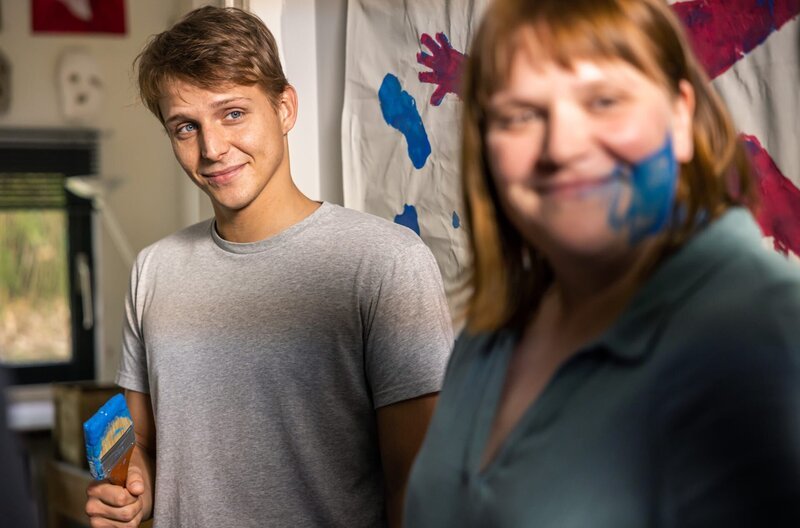 Felix (Merlin Rose) hat Eva (Stefanie Reinsperger) mit Farbe beschmiert. – Bild: WDR/​Constantin Film/​Guillaume Van Laethem