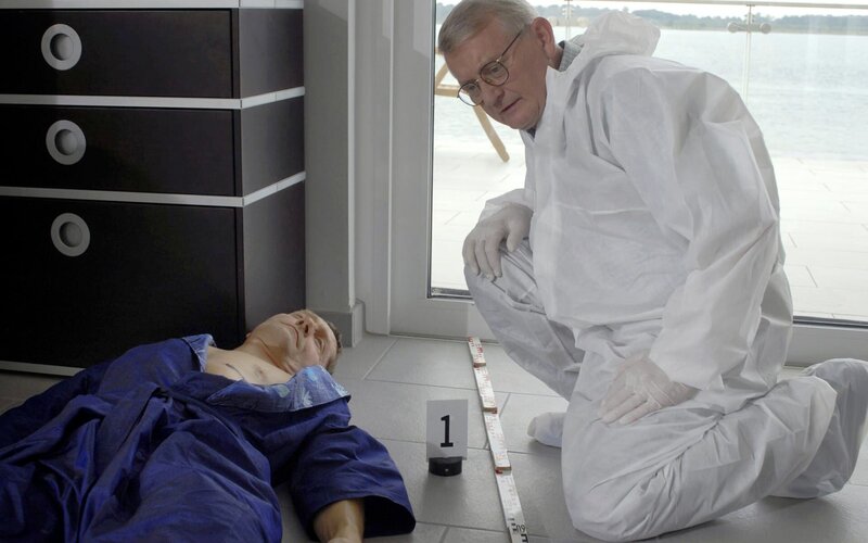 Kriminaltechniker Walter (Walter Nickel, rechts) beugt sich am Tatort über den ermordeten Peter Ludwig (Udo Schenk) und sichert Spuren am Tatort. – Bild: MDR/​Hardy Spitz
