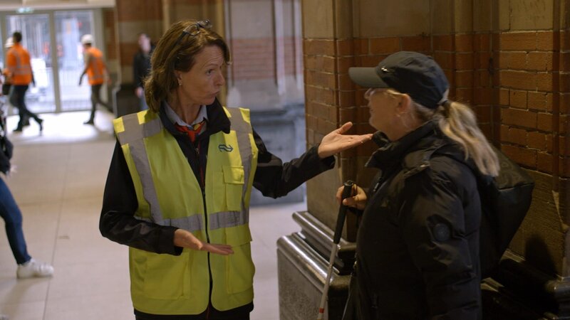 Alexandra hilft einer sehbehinderten Frau am Amsterdamer Hauptbahnhof. Eine Luftaufnahme zeigt den Transport eines Brückenteils durch Wasser in Amsterdam, Niederlande. – Bild: National Geographic