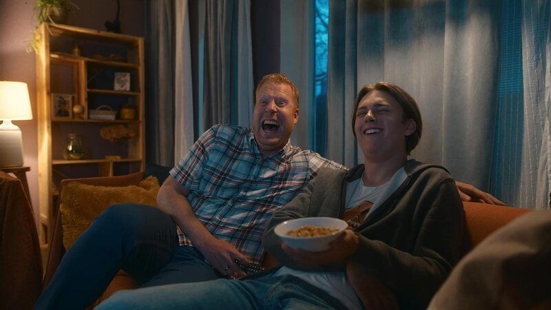 Jan (Ferdi Stofmeel) und Kees (Ole Kroes) lachen, während sie lustige Home-Videos im Fernsehen ansehen. – Bild: NDR/​NL Film