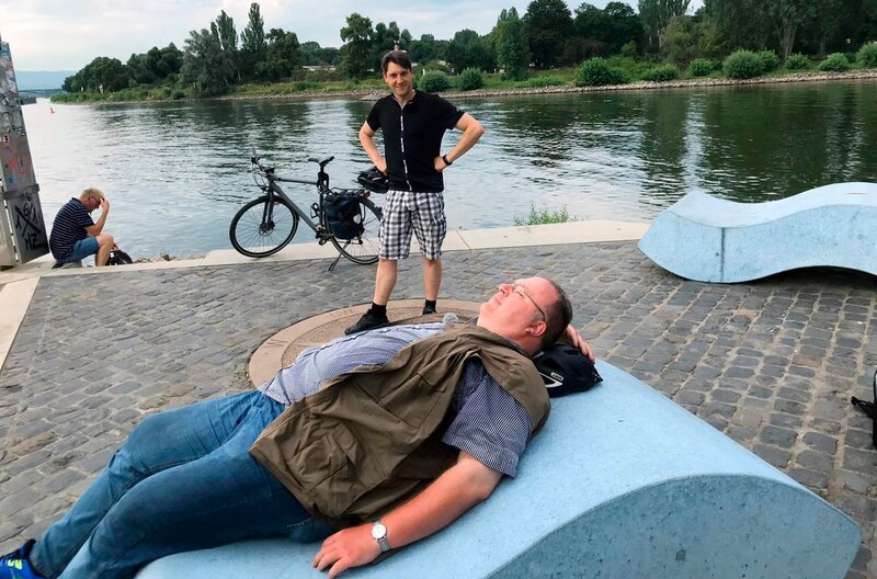 Danny Morgenstern (stehend) und sein Begleiter Holger Schulze legen auf ihrer Radreise eine Pause ein. – Bild: HR/​Nathaly Janho