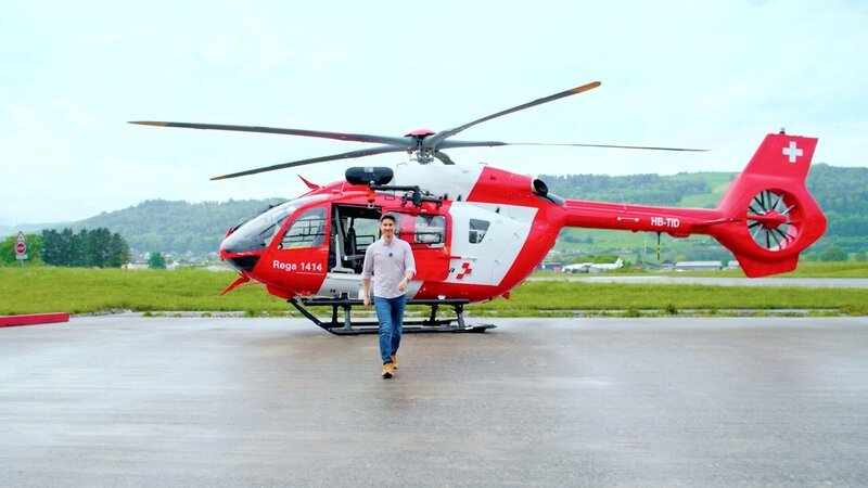 Tobias Müller vor einem Rega-Helikopter – Bild: SRF