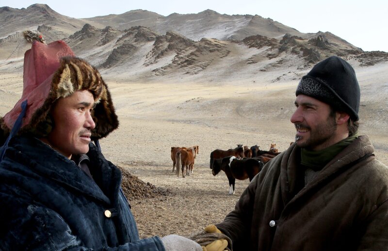 Hazen Audel (r.) ist bei dem mongolischen Steppenvolk der Kasachen zu Gast, wo er mit einem halbwilden Pferd ins Altai-Gebirge reitet. Vorher muss er allerdings einen Adler für eine bevorstehende Jagd trainieren … – Bild: National Geographic Channels/​Samantha Tollworthy