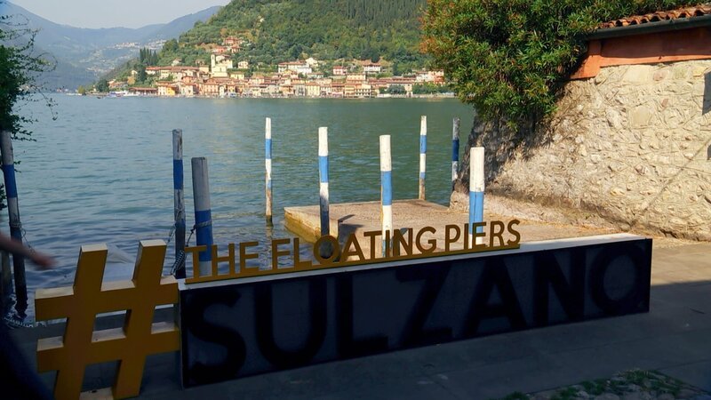 Der Verpackungskünstler Christo verwirklichte 2016 am Iseo-See sein Großprojekt „The Floating Piers“. Goldgelbe Schwimmstege verbanden die Insel Monte Isola mit dem Ufer. Das Ereignis dauerte nur 16 Tage und zog 1,2 Millionen Besucher in seinen Bann. Heute zeugt nur noch das Schild von dem Kunstprojekt. – Bild: RB, arte, Lür Wangenheim /​ ZDF
