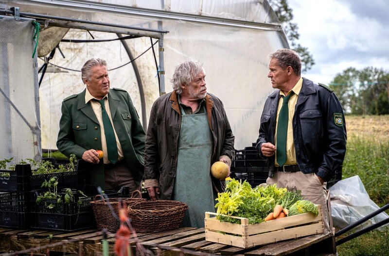 Hubert (Christian Tramitz, l.) und Girwidz (Michael Brandner, l.) verhören den Gärtner (Klaus Stiglmeier, M.). Kann er ihnen etwas über Lothar Kolb erzählen? – Bild: ARD/​Jenrick Mielke