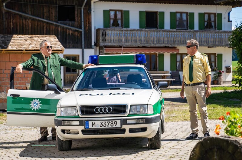 Hubert (Christian Tramitz, r.) und Girwidz (Michael Brandner, l.) werden zu einem Tatort gerufen. Auf einem Ferienbauernhof soll ein Mord geschehen sein. – Bild: ARD/​Jenrick Mielke