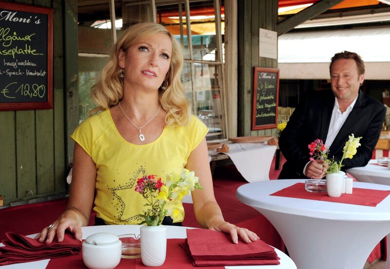 ARD HEITER BIS TÖDLICH – MÜNCHEN 7, Krimiserie mit 8 neuen Folgen, Folge 11 „Zimmer frei“, am Mittwoch um 18:50 Uhr im Ersten. Geldfälscher Sandor Malek (Rainer Wöss, r.) baggert die Moni (Monika Gruber, l.) an und flirtet so lange mit ihr, bis sie einwilligt, mit ihm abends essen zu gehen. – Bild: BR/​ARD/​Barbara Bauriedl