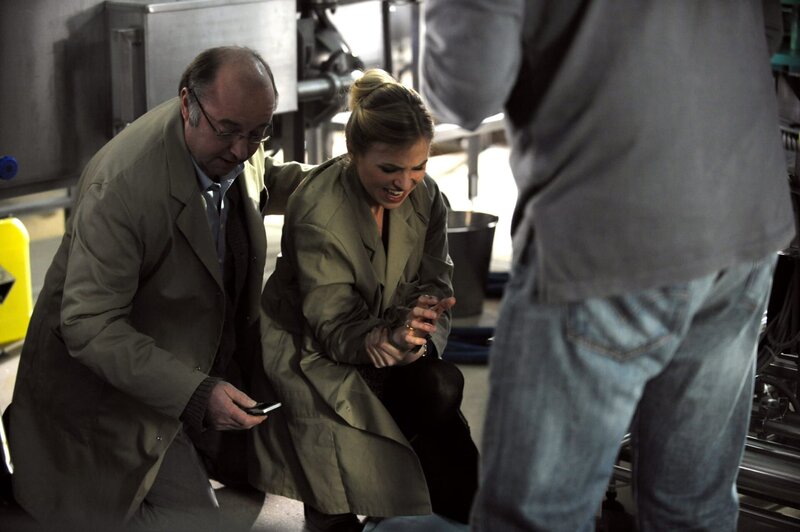 Caro hat sich am Fließband verletzt. Von links: Stadler (Heinrich Stadler) und Carolin Ertl (Teresa Rizos). – Bild: BR/​Marco Orlando Pichler