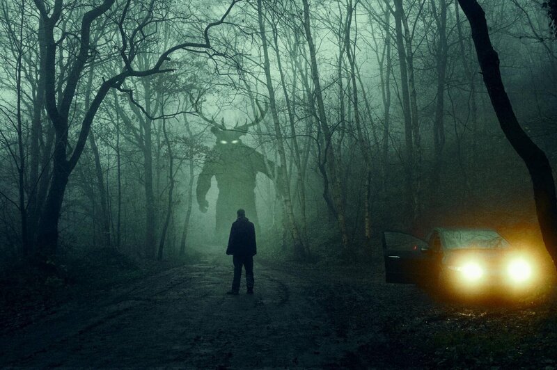 Ein Horror-Konzept. Ein Mann, der neben einem Auto steht und ein Monster mit glühenden Augen betrachtet. In einem gespenstischen, nächtlichen Winterwald Mit einer Grunge-Texturbearbeitung – Bild: Not Released (NR)/​David Wall