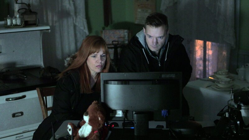 Amy Bruni and Adam Berry looking at a monitor during a nighttime investigation at the Villisca Ax House in Villisca, IA. – Bild: Travel Channel /​ Scripps