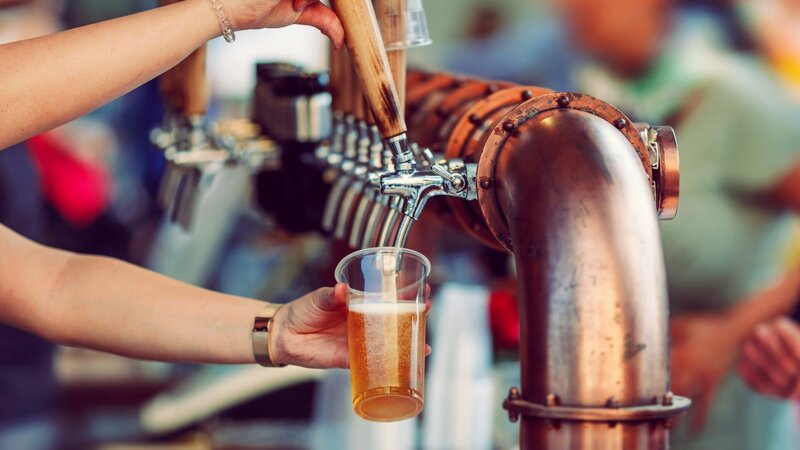 Beer tapping with traditional taps into a plastic cup and colorful blurred background – Bild: zozzzzo /​ Getty Images/​iStockphoto